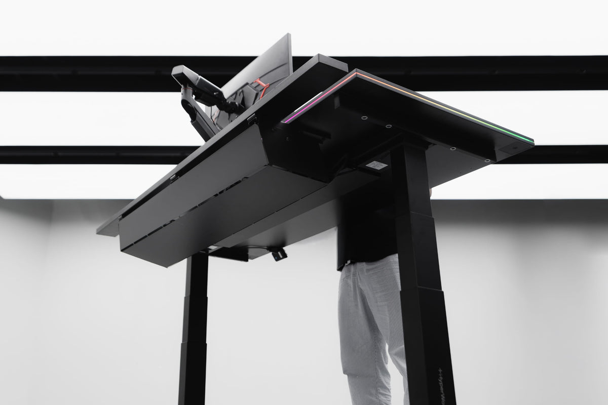 Bàn nâng hạ HyperWork với setup nhiều màn hình và thiết bị minh họa tải trọng của bàn