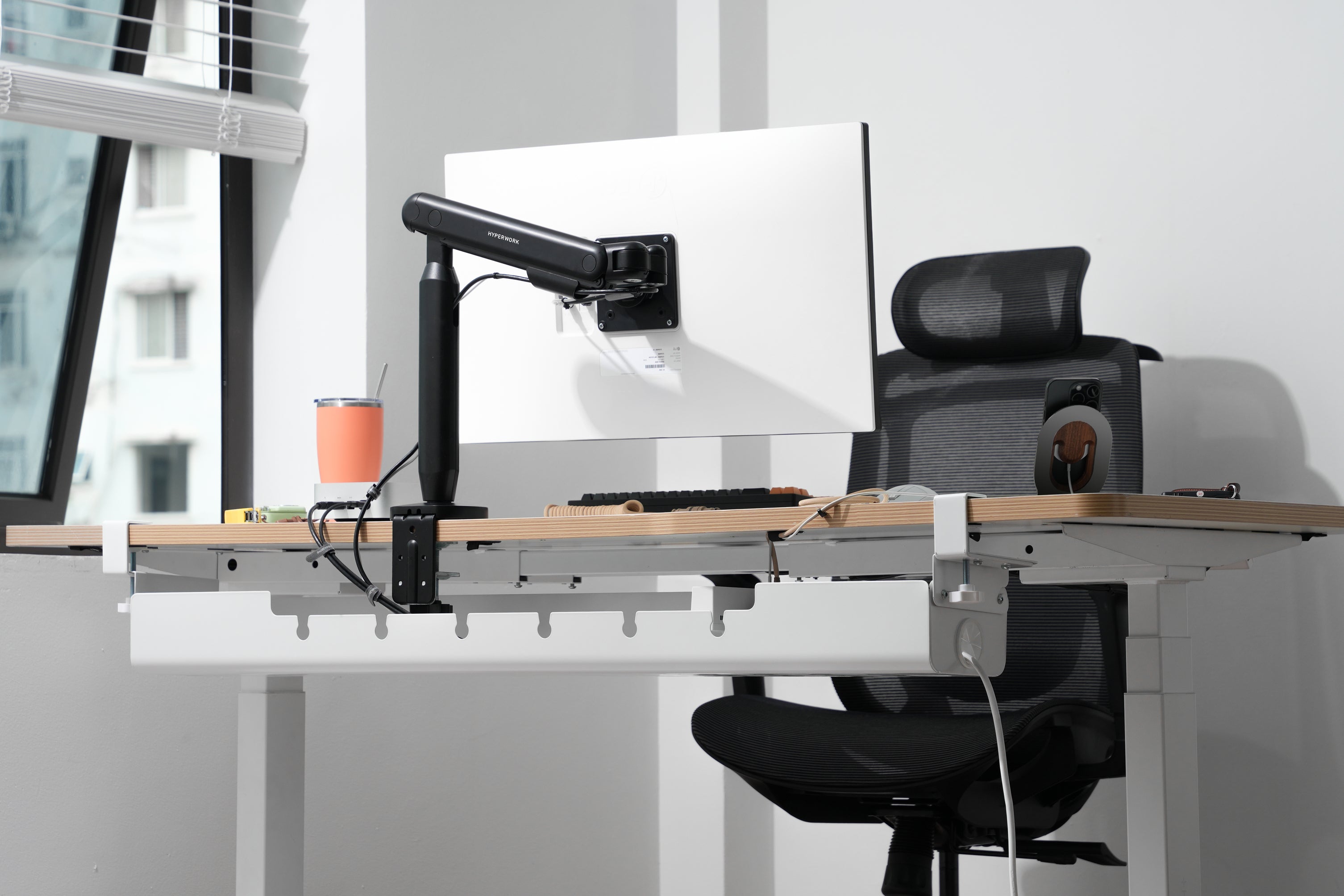 Setup nhiều thiết bị với arm màn hình và bàn nâng hạ, dây điện được quản lý gọn gàng bằng hệ thống cable management